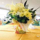 Yellow and white chrysanthemums or mums with assorted paper and sinamay wrappers